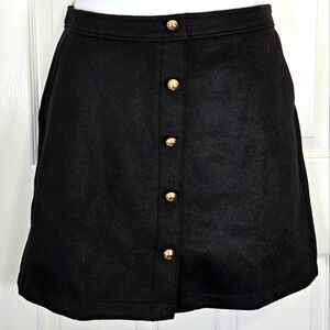 Loft, fully lined, black skirt with pockets and gold colored buttons. Size 6.